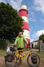 Ed Peppitt with his bicycle in front of a lighthouse